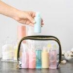 Trousse de maquillage transparente contenant des petits flacons colorés, idéale pour organiser ses produits de beauté en voyage.