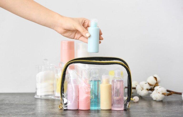 Trousse de maquillage transparente contenant des petits flacons colorés, idéale pour organiser ses produits de beauté en voyage.